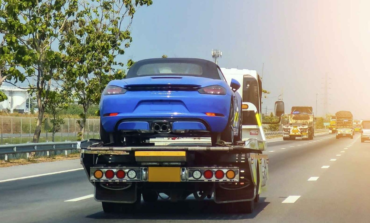 Emergency towing service transporting a sports car on a flatbed truck