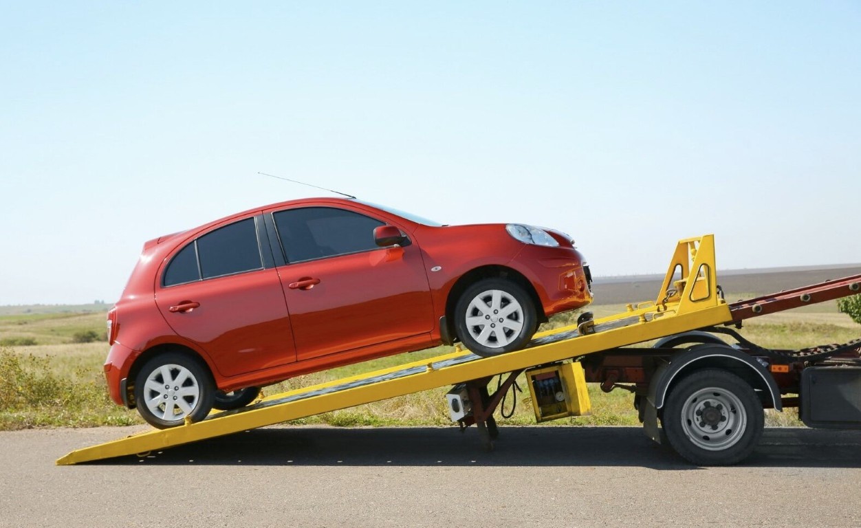Heavy duty tow truck loading a vehicle onto the flatbed for large vehicle recovery